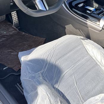 Das Bild zeigt den Innenraum eines blauen Cabriolets mit geöffnetem Verdeck. Der Fahrersitz ist mit der Smartgrip3in1 Eco abgedeckt.